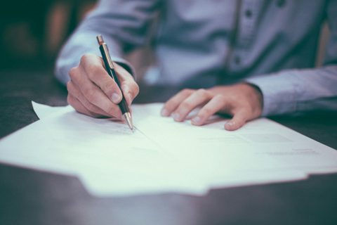 Человек подписывает договор